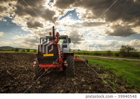 Tractor plowing fields. Preparing land for sowing. 39940548