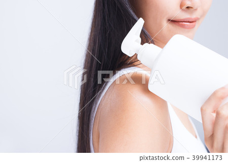 A woman is applying lotion. A woman is applying lotion. 39941173