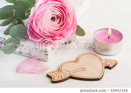 Pink buttercup flower with wooden heart Pink buttercup flower with wooden heart 39942166