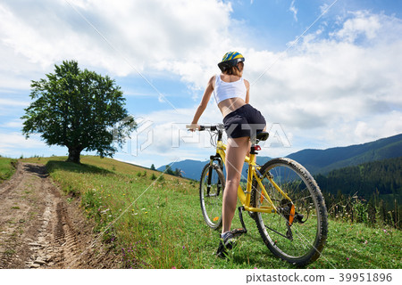 Young happy woman cycling on mountain bike at summer day 39951896