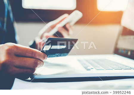 Man Holding Credit Card And Using Cell Phone  39952246