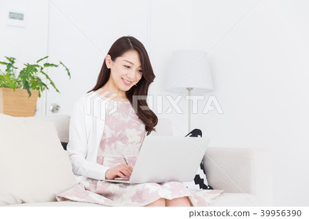 觀看一台便攜式計算機的婦女在屋子裡 39956390