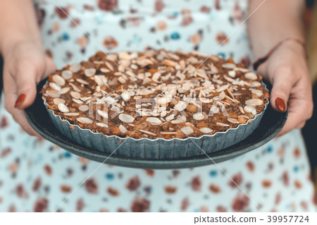 Woman in white dress holds banana cake  in hands.  39957724