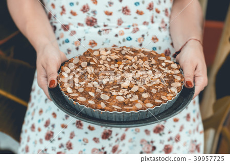 Woman in white dress holds banana cake  in hands.  39957725