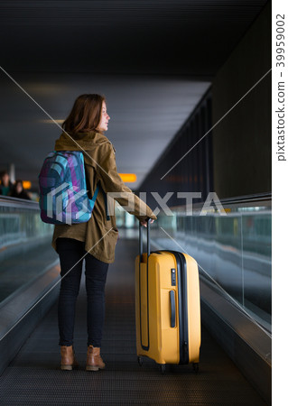 the girl is riding on the travolator 39959002