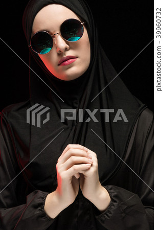 Portrait of beautiful stylish young muslim woman wearing black hijab and sunglasses as modern Portrait of beautiful stylish young muslim woman wearing black hijab and sunglasses as modern 39960732