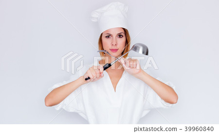 woman in cook uniform holding kitchenware 39960840