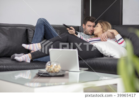 Happy young couple relaxing and watching TV at home. 39965417