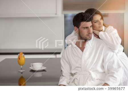 Portrait of a man and his wife in the kitchen while having breakfast 39965677