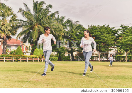 Parents and daughters go for a walk in the park. 39966105