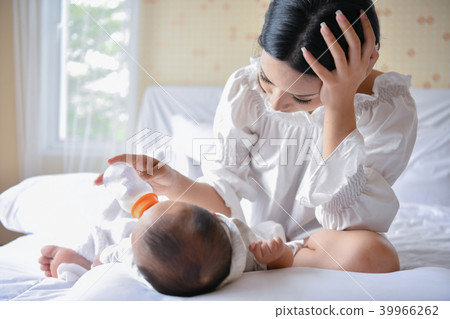 Newborn Concept. Mom is breastfeeding in the bedroom. Newborn Concept. Mom is breastfeeding in the bedroom. 39966262