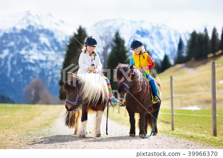 Kids riding pony. Child on horse in Alps mountains 39966370