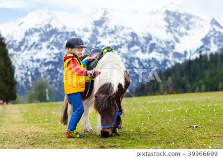 Kids riding pony. Child on horse in Alps mountains 39966699