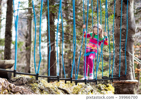 Child in adventure park. Kids climbing rope trail. 39966700