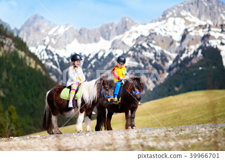 Kids riding pony. Child on horse in Alps mountains 39966701