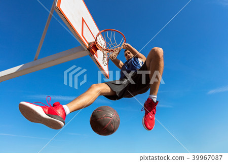 Slam Dunk. Side view of young basketball player making slam dunk 39967087