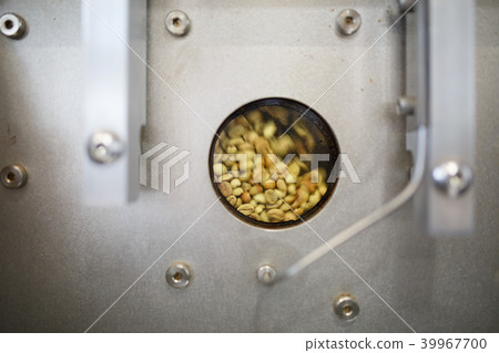 Photo of unroasted coffee beans in roaster 39967700