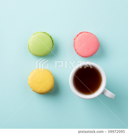 Cup of tea, colorful macarons on blue background 39972095