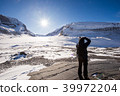 Young male photographer taking picture of Athabasca Glacier 39972204