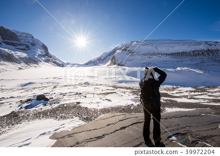 Young male photographer taking picture of Athabasca Glacier Young male photographer taking picture of Athabasca Glacier 39972204