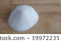 Pile of white granulated sugar on a wood cutting board 39972235
