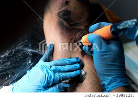 Male tattooist making tattoo on shoulder, closeup Male tattooist making tattoo on shoulder, closeup 39981283