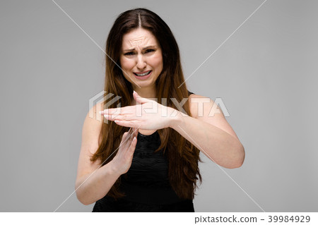 Emotional sad plus size model standing in studio showing stop gesture show time-out sign 39984929
