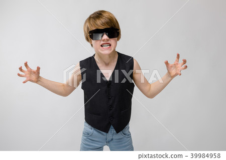 Portrait of adorable funnylittle boy standing in studio with sunglasses showing agression anger Portrait of adorable funnylittle boy standing in studio with sunglasses showing agression anger 39984958
