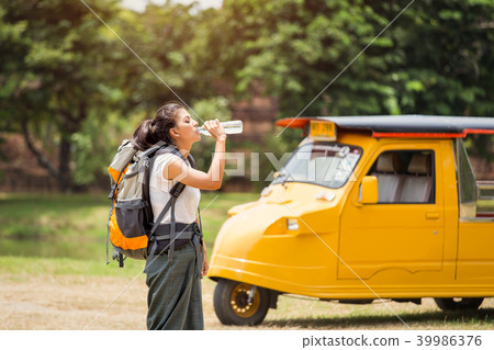 Young asian female traveler is drinking water Young asian female traveler is drinking water 39986376