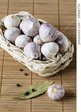 Basket with garlic bulbs, one not in the basket 39986754