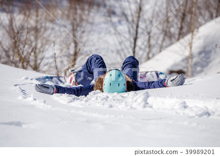 Portrait from back of athlete in helmet lying on snowy slope Portrait from back of athlete in helmet lying on snowy slope 39989201