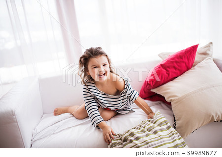 A small happy girl in striped T-shirt at home having fun. 39989677