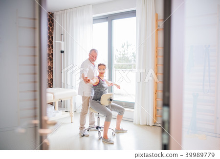 Senior male physiotherapist working with a female patient. 39989779