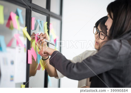 Businesspeople putting ideas at sticky notes. 39990884