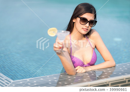 Woman in bikini at swimming pool and hold cocktail Woman in bikini at swimming pool and hold cocktail 39990981