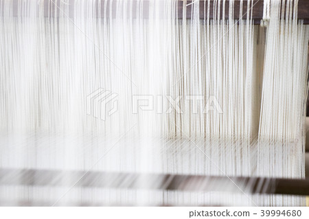 Closed up of loom with white thread background Closed up of loom with white thread background 39994680