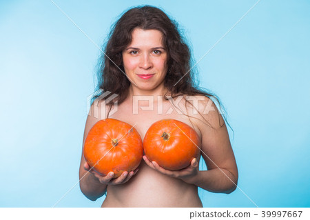Pumpkins on a female breast - concept silicone breast and plastic surgery. Pumpkins on a female breast - concept silicone breast and plastic surgery. 39997667