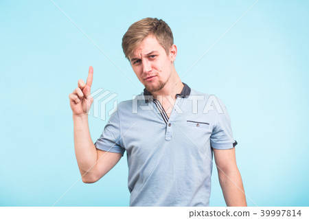 Advertisement concept. Successful caucasian man with beaming smile on blue background is pointing on 39997814