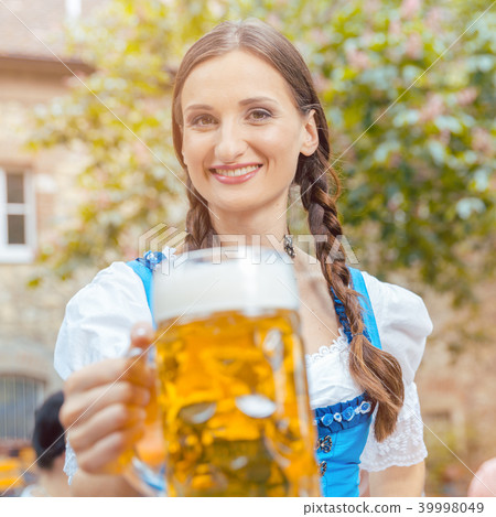 Woman wearing Dirndl drinking beer Woman wearing Dirndl drinking beer 39998049
