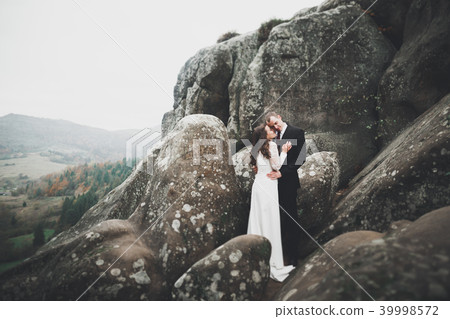 Wedding couple in love kissing and hugging near rocks on beautiful landscape 39998572