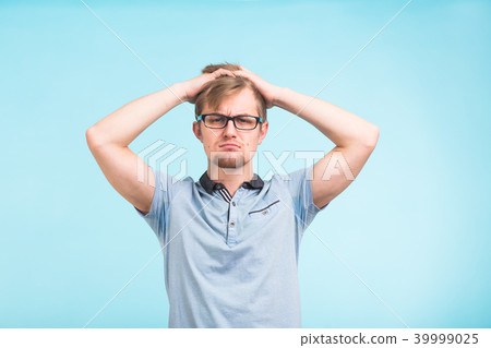 Puzzled hesitant male full of doubts, should decide, has indecisive expression, put his hands on 39999025