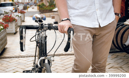 Closeup image of young hipster man walking with retro bicycle 39999200
