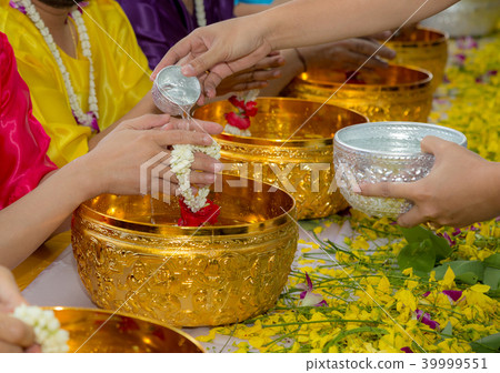Young people is pouring water to older people 39999551