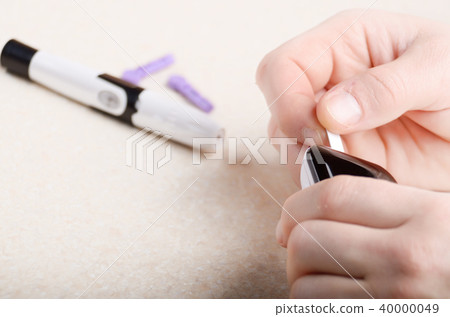 Man inserting blood test strip in glucometer  40000049