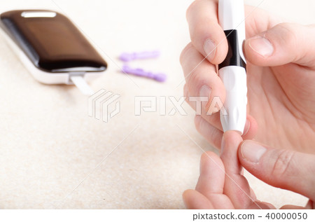 Man Pierce his fingertip before doing blood test 40000050