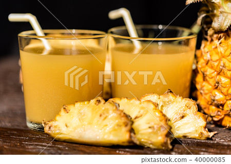 Pineapple juice and slice placed on a wooden table 40000085