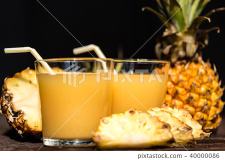 Pineapple juice and slice placed on a wooden table Pineapple juice and slice placed on a wooden table 40000086