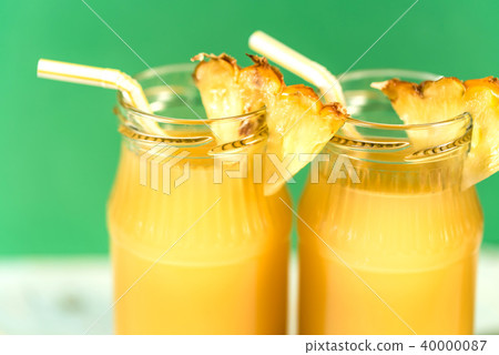 Pineapple juice and slice placed on a wooden table Pineapple juice and slice placed on a wooden table 40000087