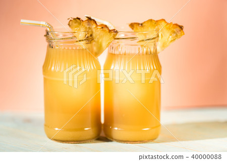 Pineapple juice and slice placed on a wooden table Pineapple juice and slice placed on a wooden table 40000088