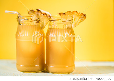 Pineapple juice and slice placed on a wooden table Pineapple juice and slice placed on a wooden table 40000099